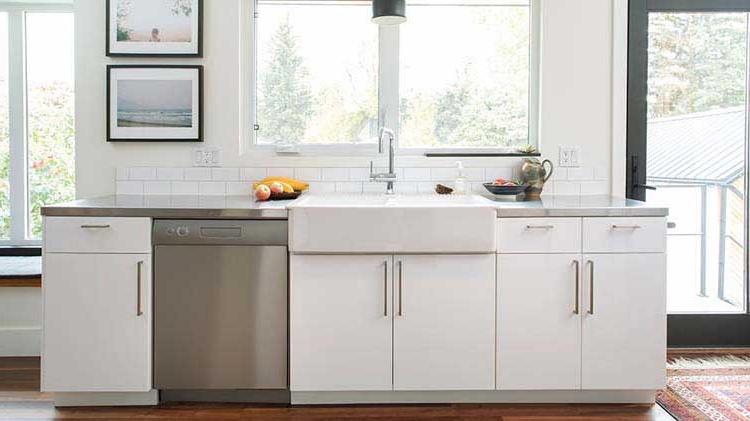 Display of kitchen counter with lower cabinets, sink and dishwasher.